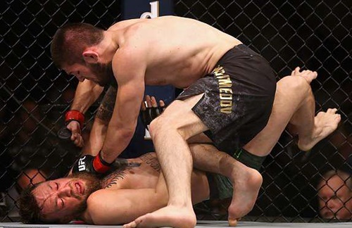 Khabib liên tục dồn McGregor vào cạnh lưới và sử dụng các đòn khóa, siết với đối thủ. Ảnh: LLC.