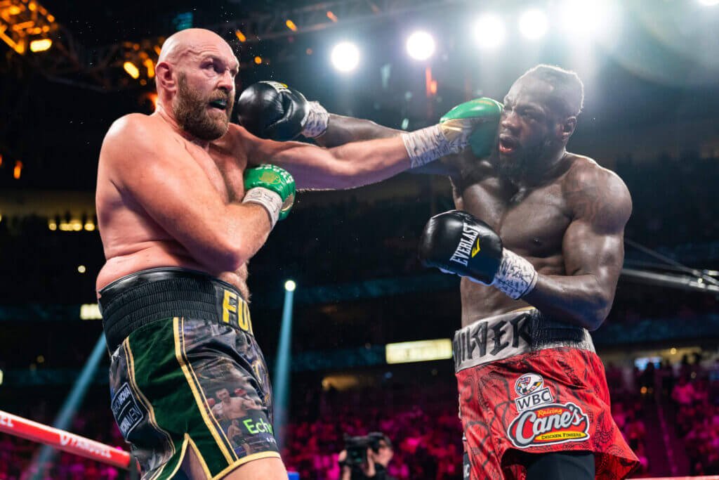 Wilder (phải) thua hai và hoà một trong ba cuộc đối đầu Fury. Ảnh: AFP